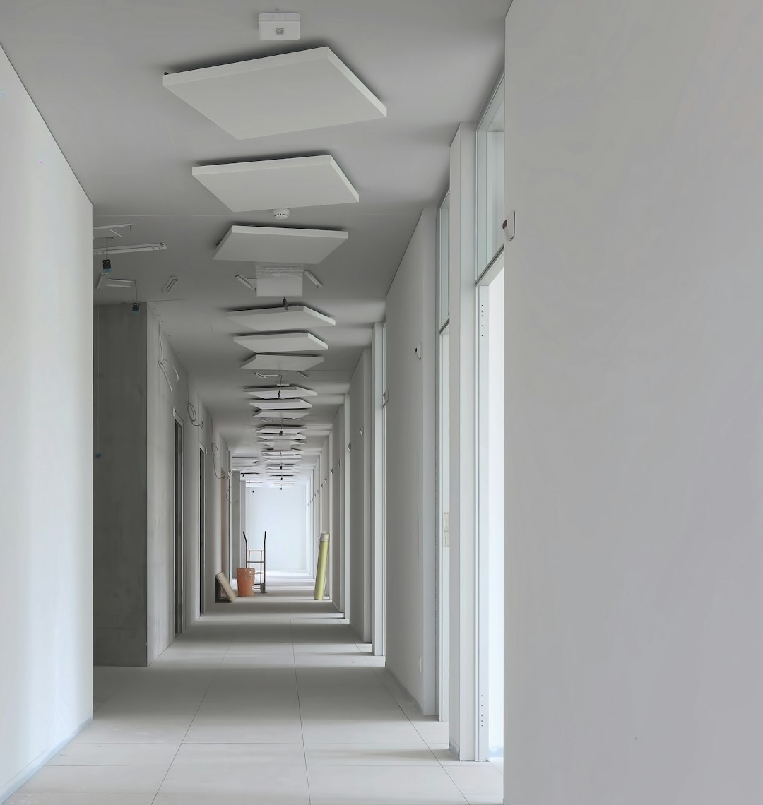a long hallway with white walls and ceiling lights